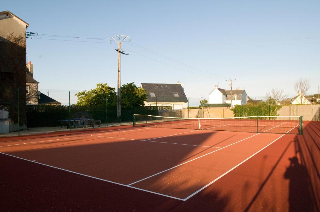 a tennis court with a net on top of it at Le Château de Sable in Plougasnou