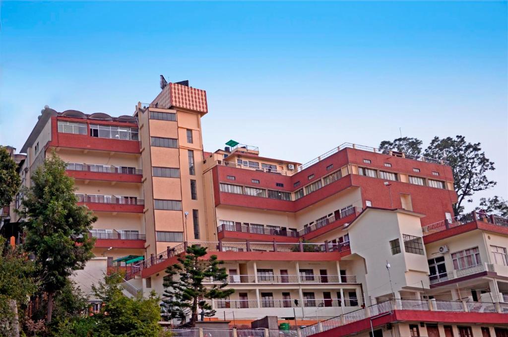 un grand bâtiment en briques rouges dans l'établissement Hotel Shikhar & Restaurant, à Almora