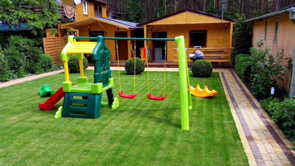 a playground in a yard with green grass at Alkado Domki Jurata in Jurata
