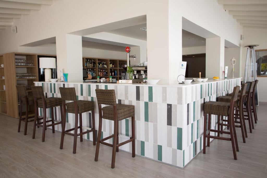 a bar with a bunch of chairs around it at Hotel Rosamar - Emar Hotels in Es Pujols