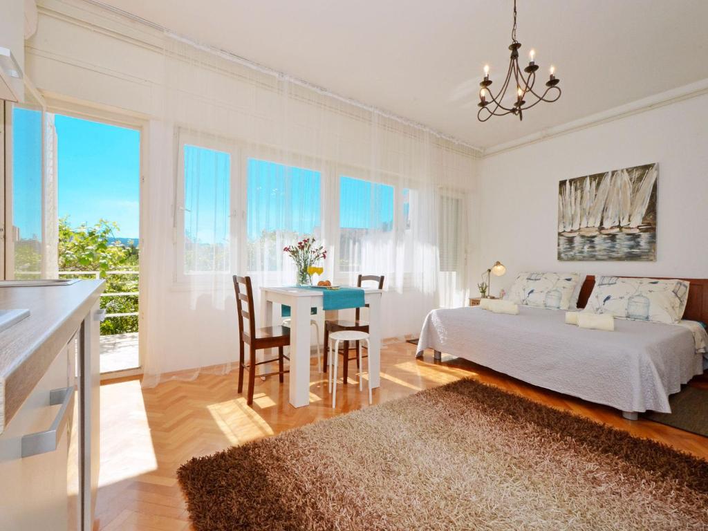 um quarto branco com uma cama, uma mesa e cadeiras em Studio apartment Andela em Marina