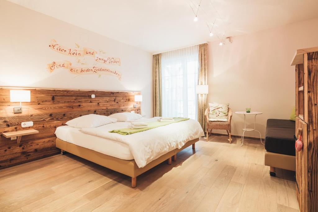 a bedroom with a large bed with a wooden wall at Weinwirtshaus Wlaschits in Klingenbach