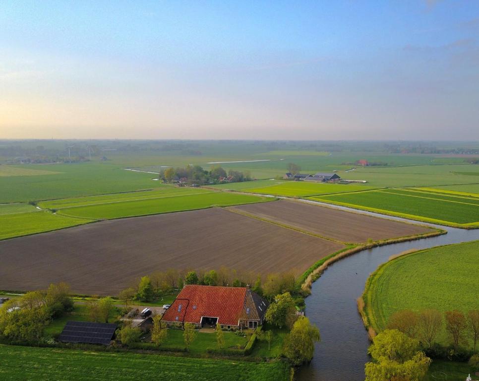 an aerial view of a farm with a house and a river at Gastenverblijf Bonga Stee in Roodhuis