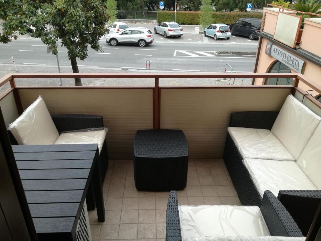 a balcony with two benches and a parking lot at Bardolino Via Marconi in Bardolino