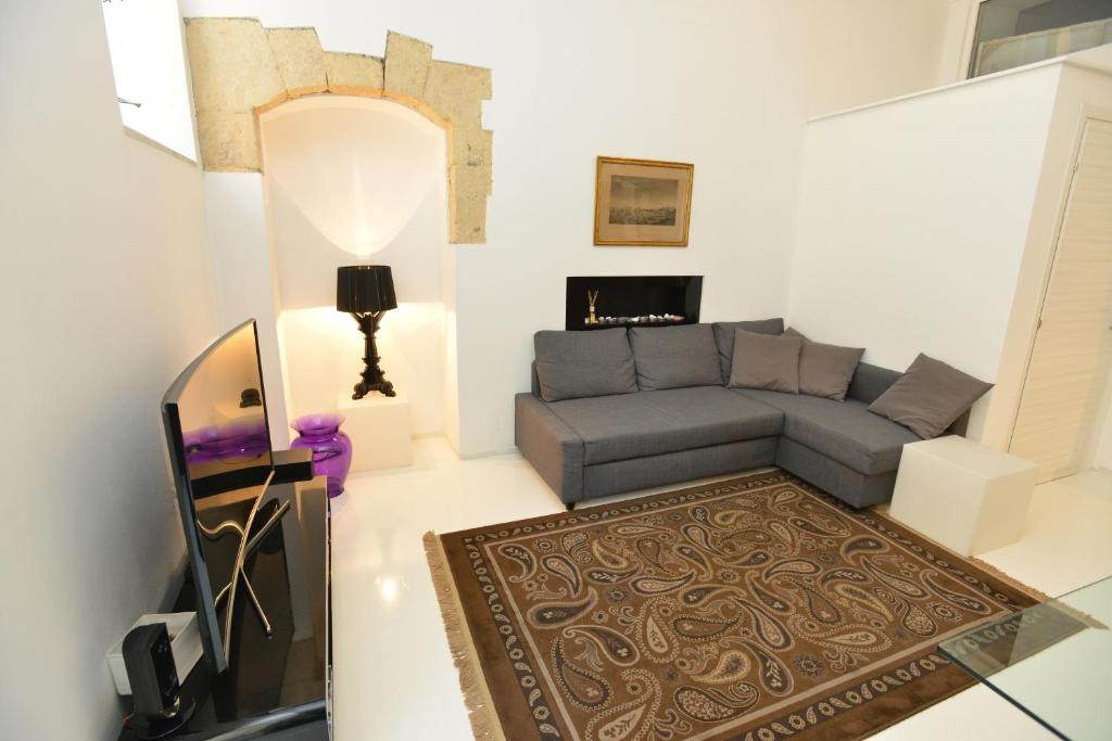 ein Wohnzimmer mit einem Sofa und einem TV in der Unterkunft IzzHome Light in Cagliari