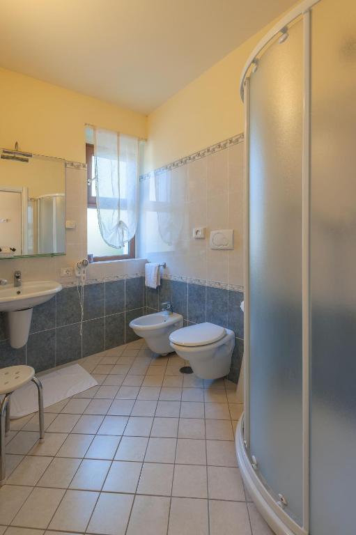 łazienka z toaletą, umywalką i prysznicem w obiekcie Hotel Saturno Fonte Pura w mieście Saturnia