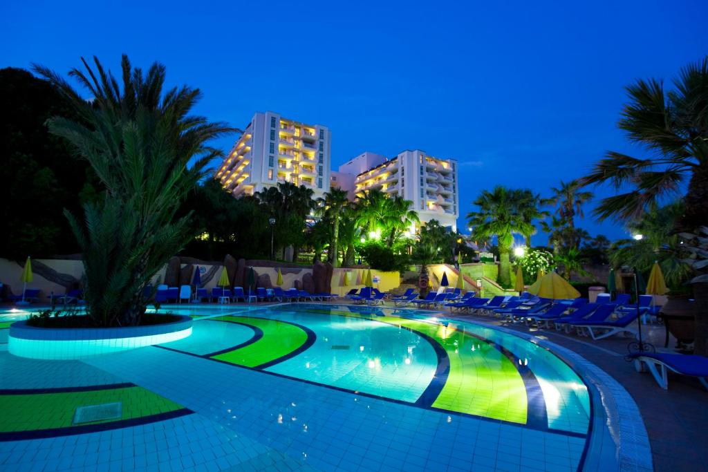 ein Schwimmbad in einem Resort in der Nacht in der Unterkunft Fantasia Deluxe Hotel in Kusadası