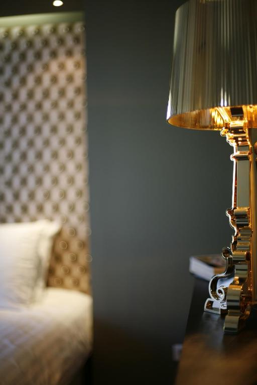 a lamp sitting on a table next to a bed at Les 4 étoiles in Montpellier