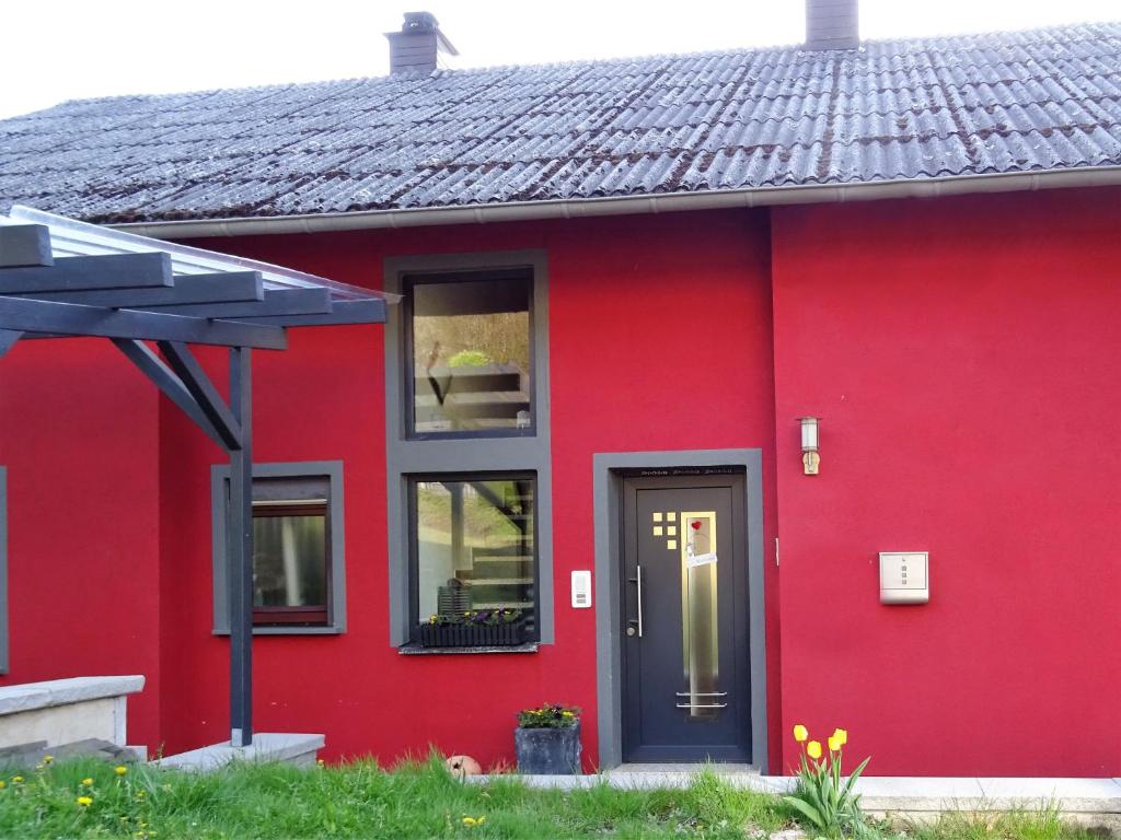 una casa roja con una puerta negra en Haus Am Sonnenberg, en Ulmen