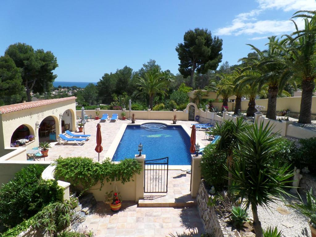 una piscina en un complejo con palmeras en Villa Senomar, en Benissa