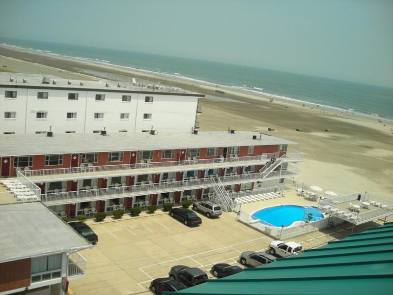a hotel with a parking lot next to a beach at Astronaut Motel in Wildwood Crest