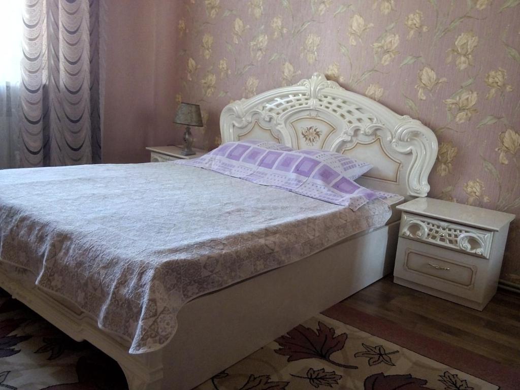 1 dormitorio con cama blanca y mesita de noche en Apartment on Kirova 3, en Eupatoria