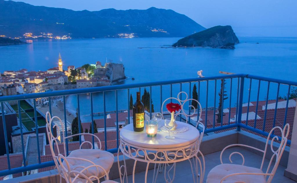 uma mesa e cadeiras numa varanda com vista para o oceano em Apartments Inspiration em Budva