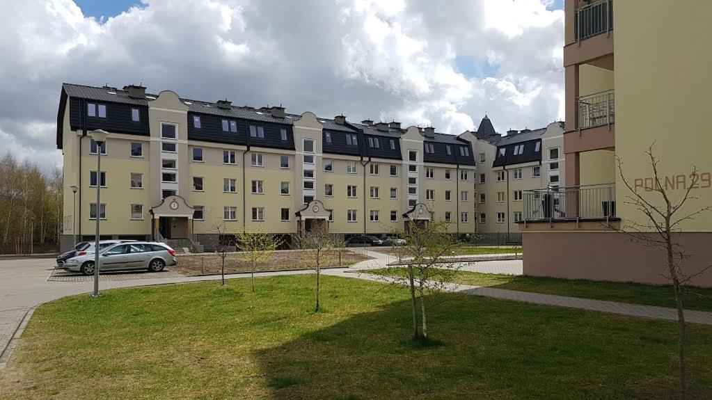 un grand bâtiment avec une voiture garée devant lui dans l'établissement Apartament Polna, à Szczecinek