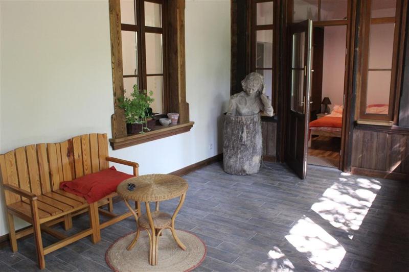 um quarto com um banco, uma mesa e uma estátua em Willa Widok - Apartament Naleczow em Nałęczów