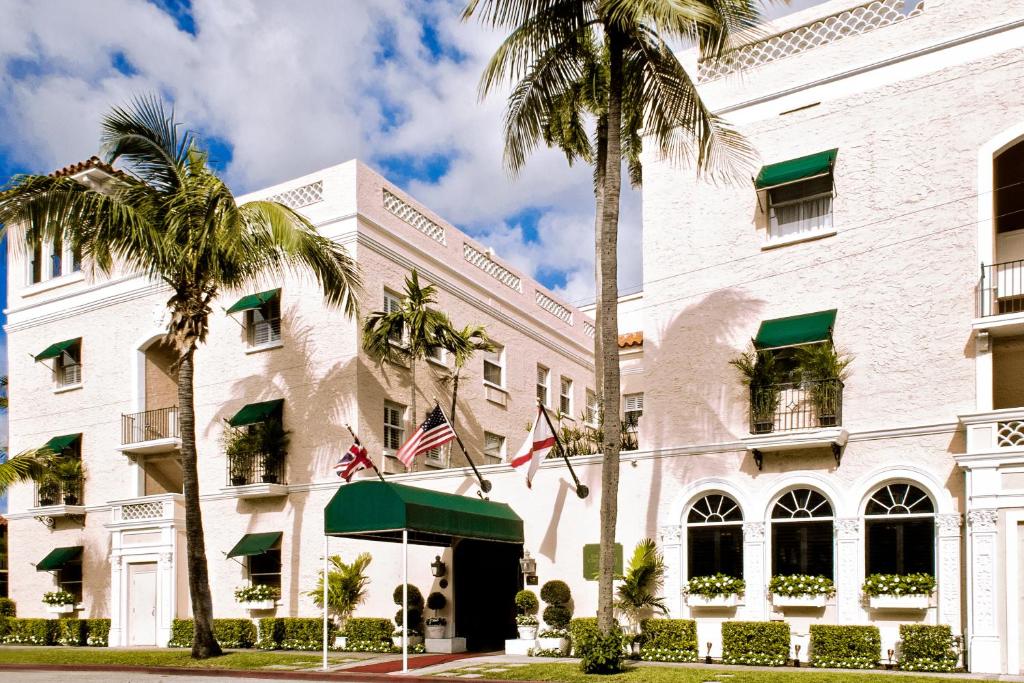 a palm tree in front of a large building at The Chesterfield Hotel Palm Beach in Palm Beach