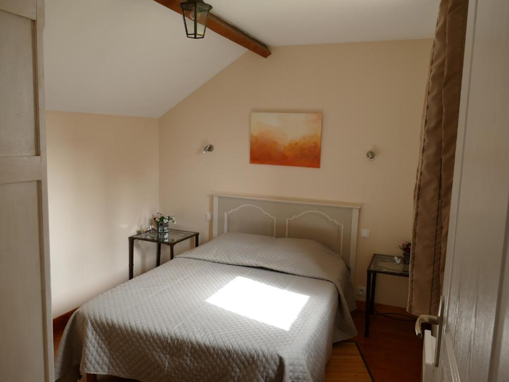 een slaapkamer met een bed en 2 bijzettafels bij Gîte Sourdeval in Sourdeval