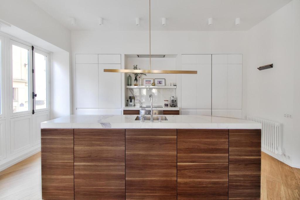 - une cuisine avec un grand îlot en bois et un évier dans l'établissement Rue du Louvre - Luxury apartment, à Paris