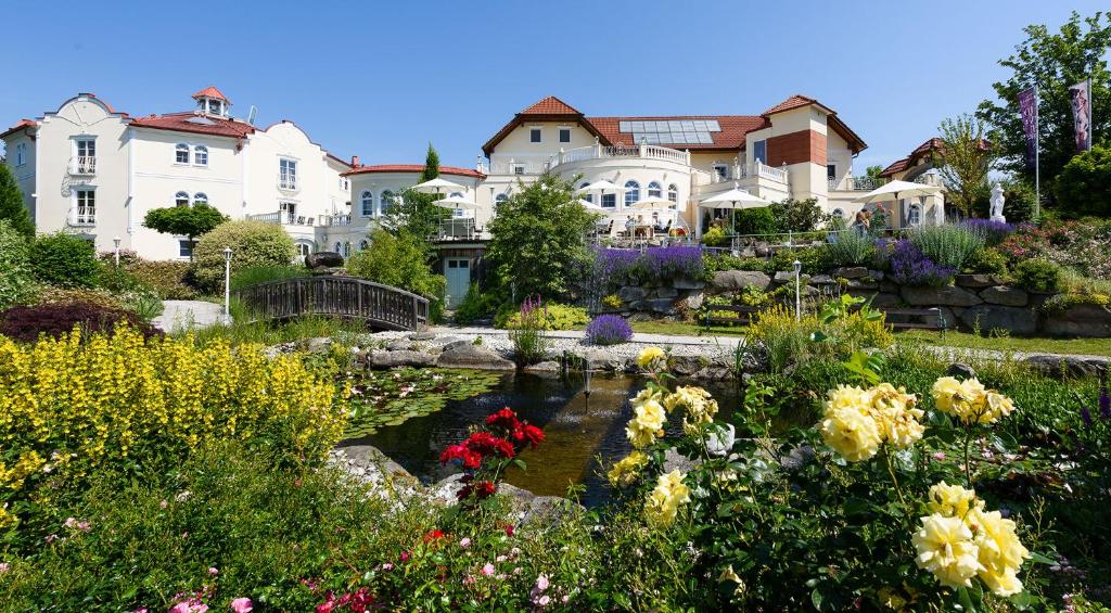 a garden in front of a large house with a pond at Bergergut Geniesserhotel in Afiesl