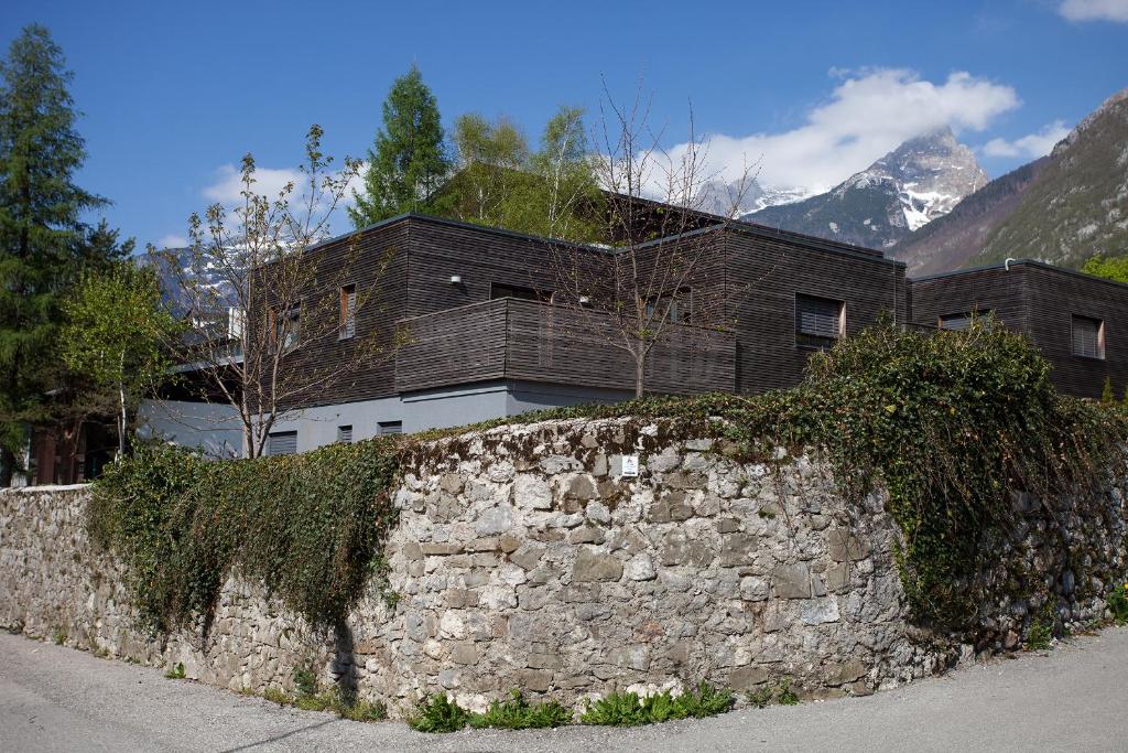 eine Steinmauer mit einem Haus dahinter in der Unterkunft Sunny Villa in Bovec