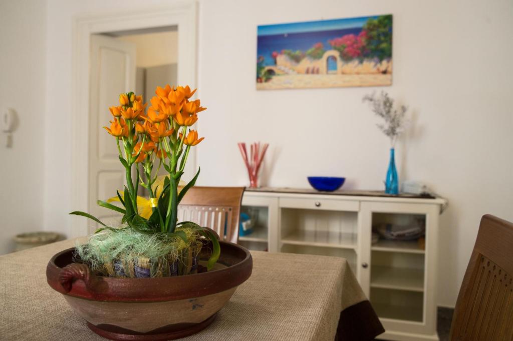 un vase avec des fleurs orange assis sur une table dans l'établissement Da zia Concetta, à Campi Salentina