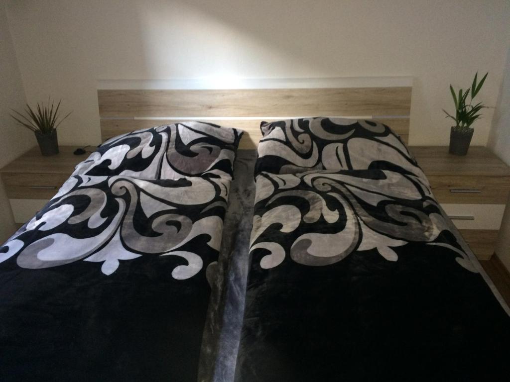 a bed with a black and white pattern on it at Apartman Za Potokem in Luhačovice
