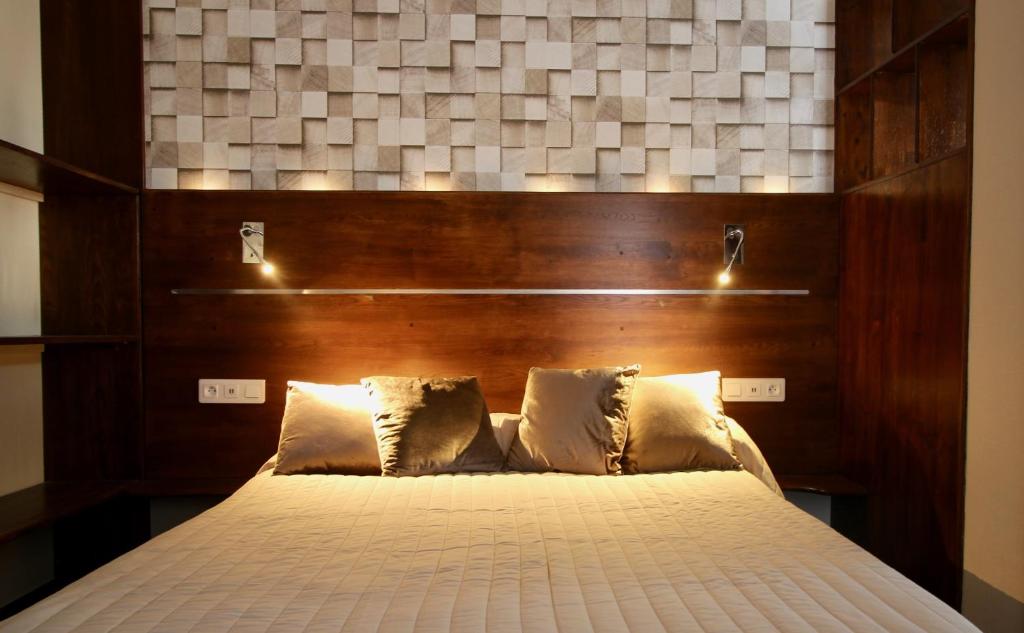 a bedroom with a bed with a wooden headboard at Hotel des Pyrénées in Paris