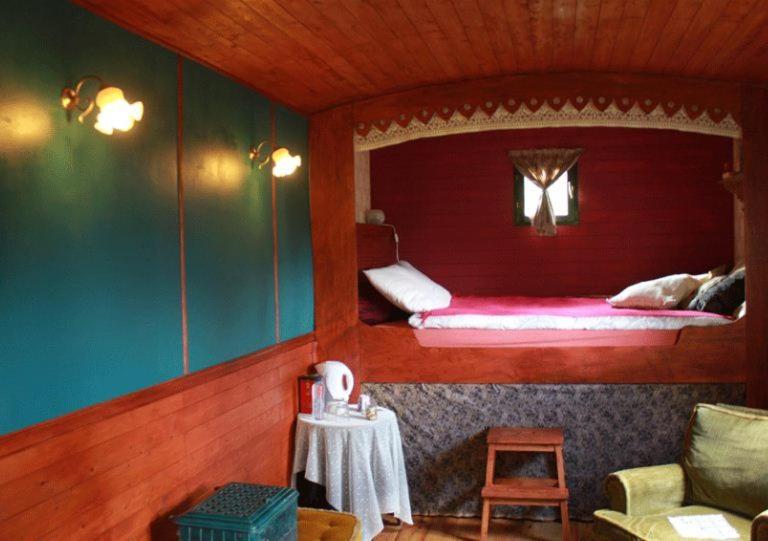 een kleine kamer met een bed en een tafel bij Gipsy Caravan in Ittre