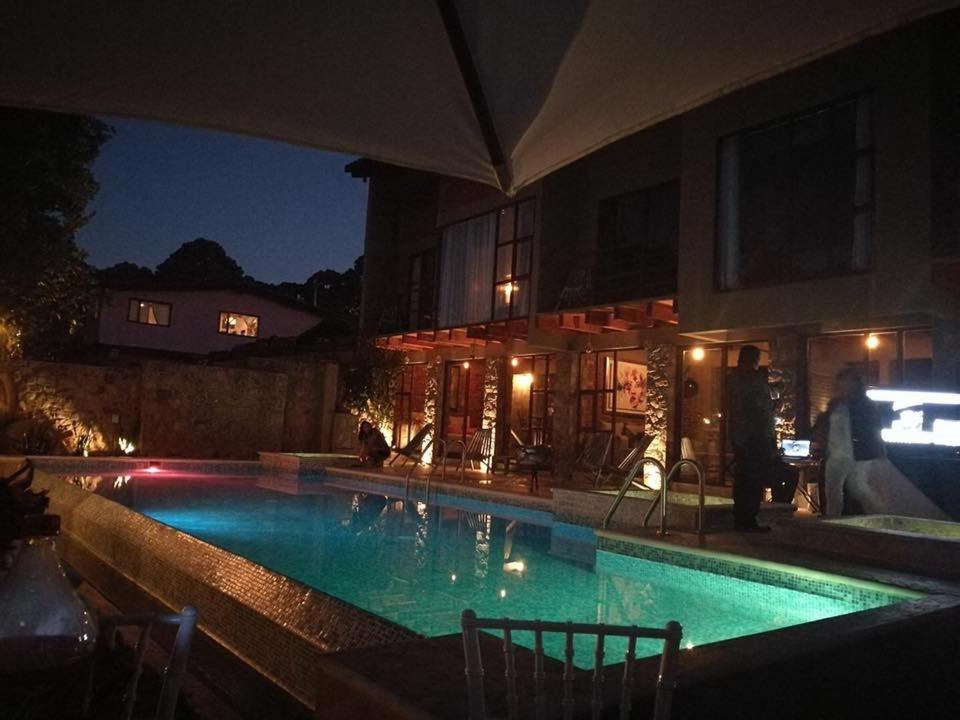 a large swimming pool in front of a house at night at Casa Ndomi in Valle de Bravo