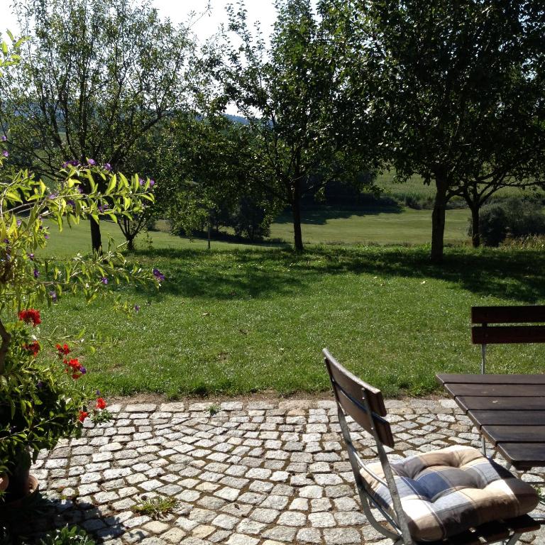a park bench sitting next to a field with trees at Ferienwohnung Familie Kitzke in Teisnach