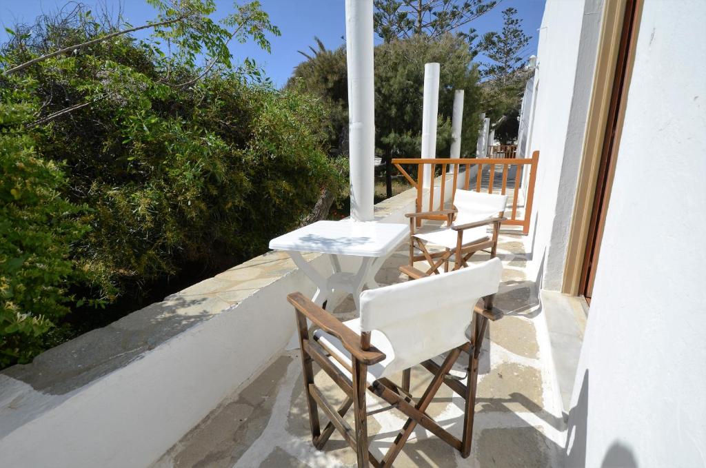 een rij stoelen en een tafel op een balkon bij Madoupa Beach Apartments in Ornos