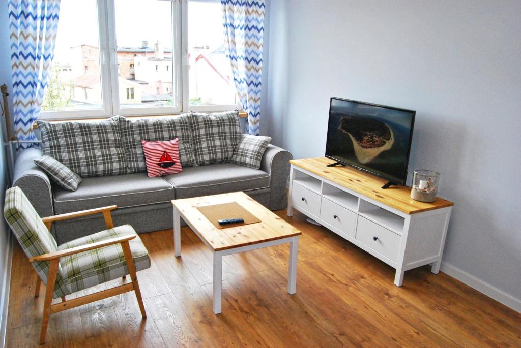 a living room with a couch and a coffee table at HelApart - Bałtyk in Hel