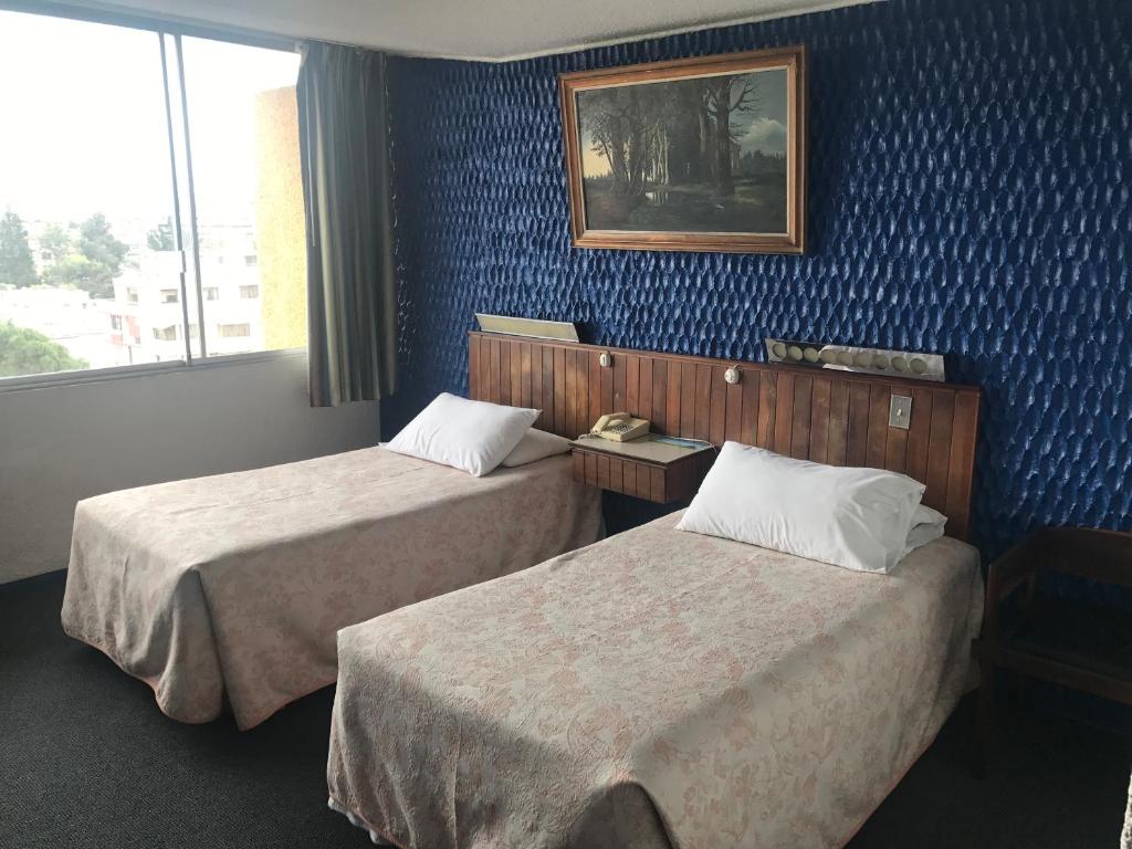 Postel nebo postele na pokoji v ubytování Hotel Savoy Inn