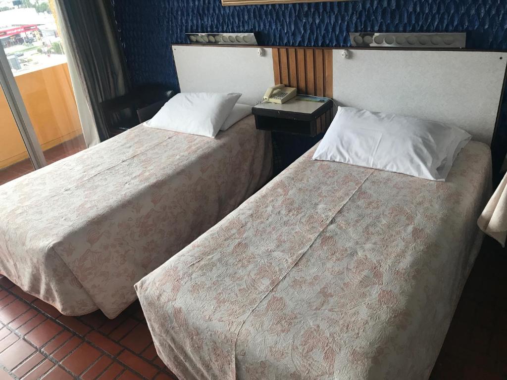 Postel nebo postele na pokoji v ubytování Hotel Savoy Inn