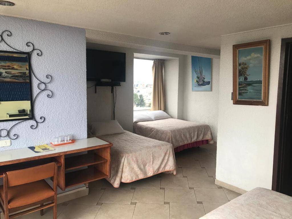 Postel nebo postele na pokoji v ubytování Hotel Savoy Inn
