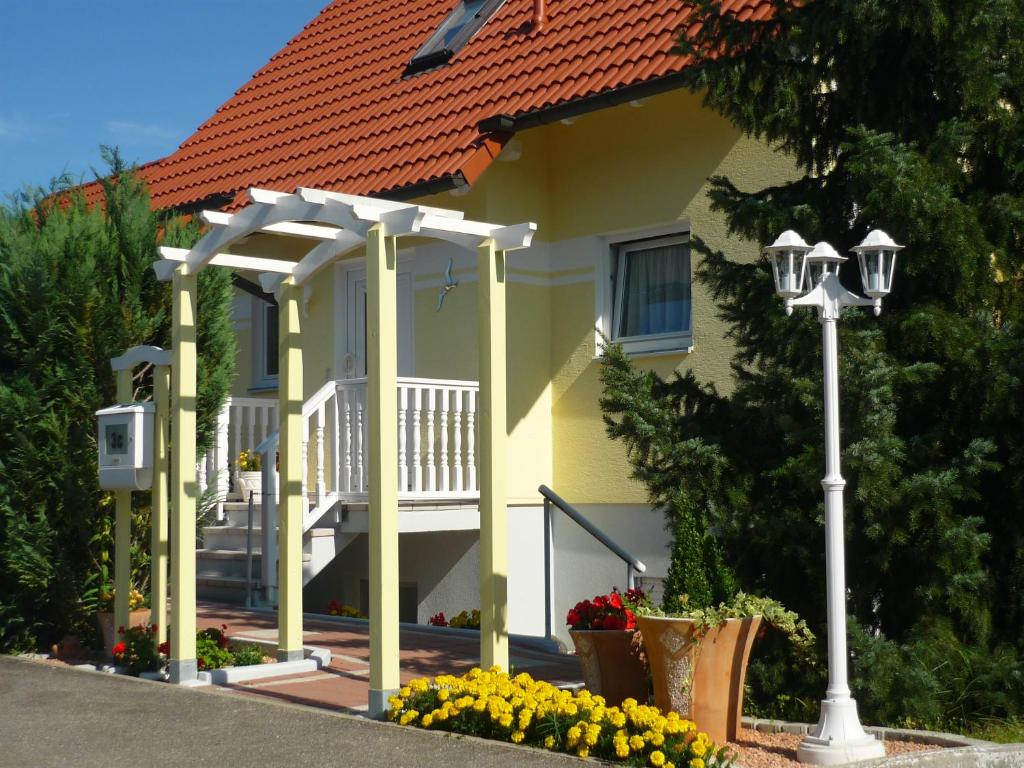 Ferienwohnung Kessler في روست: منزل أصفر مع شرفة وضوء الشارع