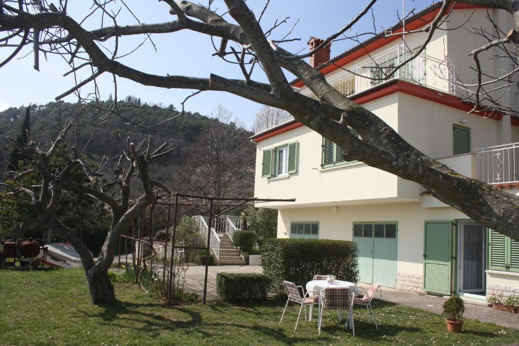a house with a table and chairs in the yard at Branka Apartments in Labin
