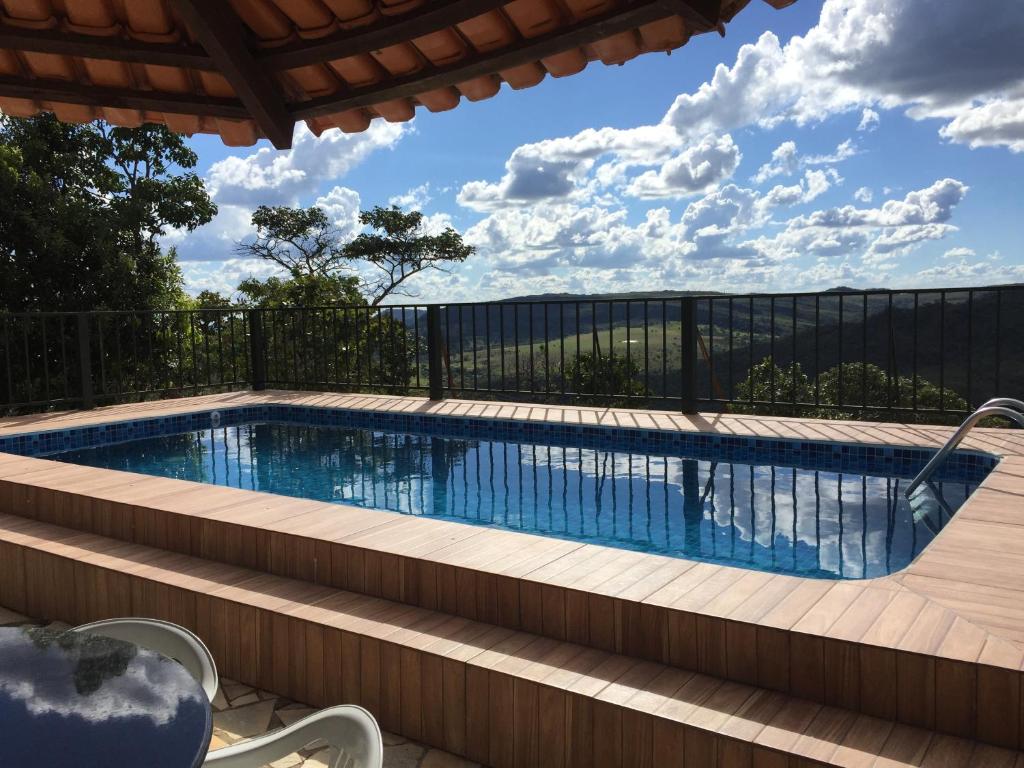 a swimming pool with a fence around it at Pousada Recanto das Pedras São Leopoldo in Pirenópolis