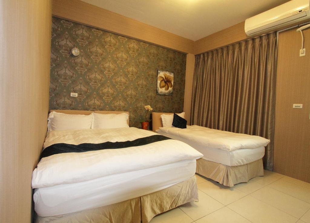 花蓮市的住宿－歡天喜地民宿，酒店客房设有两张床和窗户。
