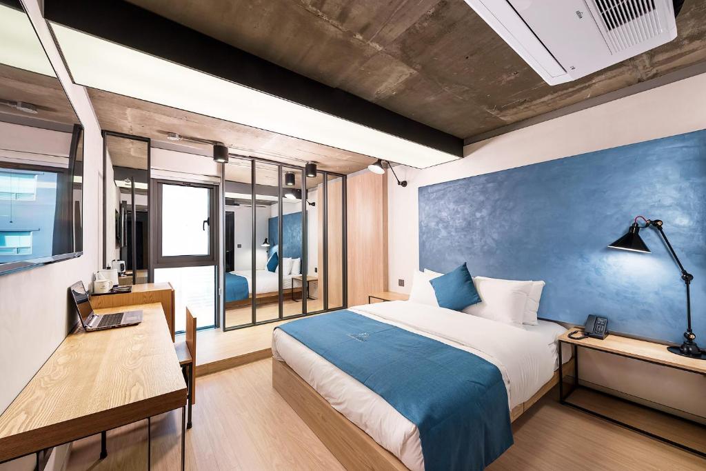 a bedroom with a bed and a table and a desk at Delight Hotel Jamsil in Seoul