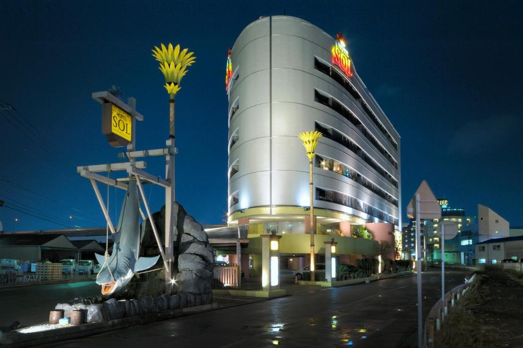 um edifício com um sinal em cima dele à noite em HOTEL SOL em Fukuoka
