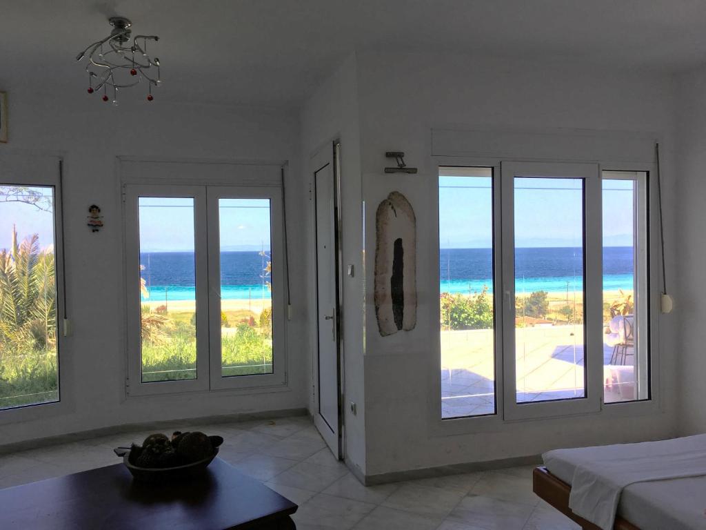 a room with three windows with a view of the ocean at Seaview dreams in Ormos Panagias