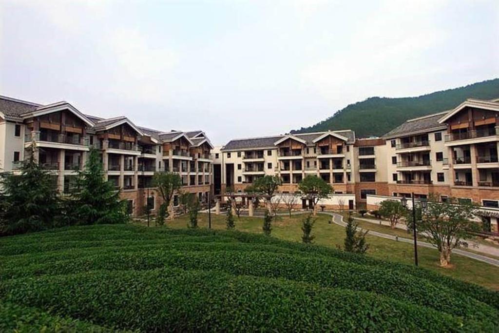 szereg budynków apartamentowych z zielonym polem w obiekcie Yuyao Yangming Hot Spring Resort w mieście Yuyao