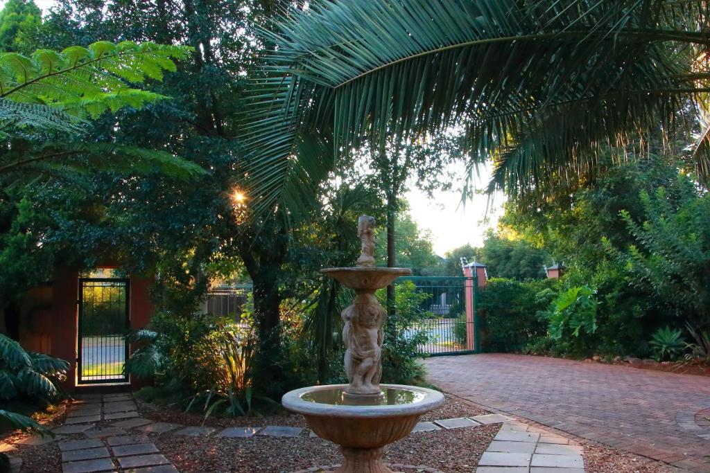 a fountain sitting in the middle of a park at Rozendal Guest House in Centurion