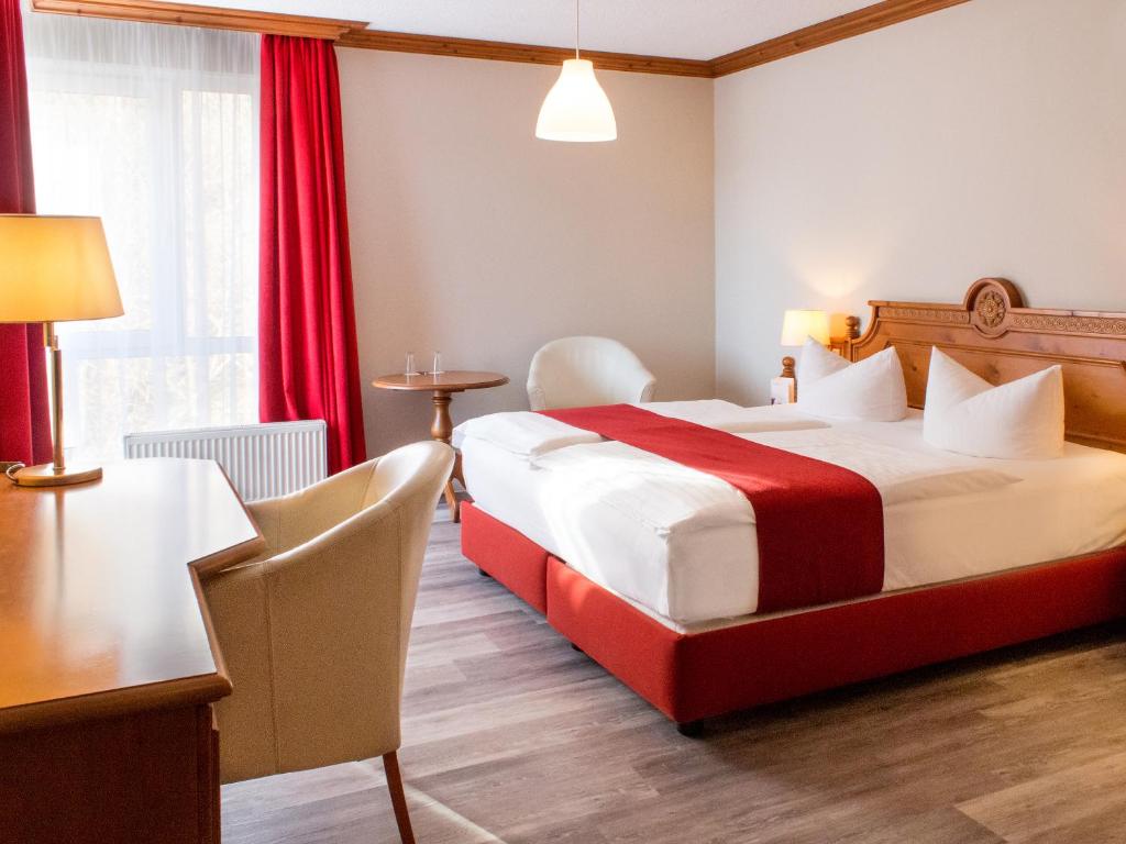 プラウエンにあるDORMERO Hotel Plauenのベッドとテーブルが備わるホテルルームです。
