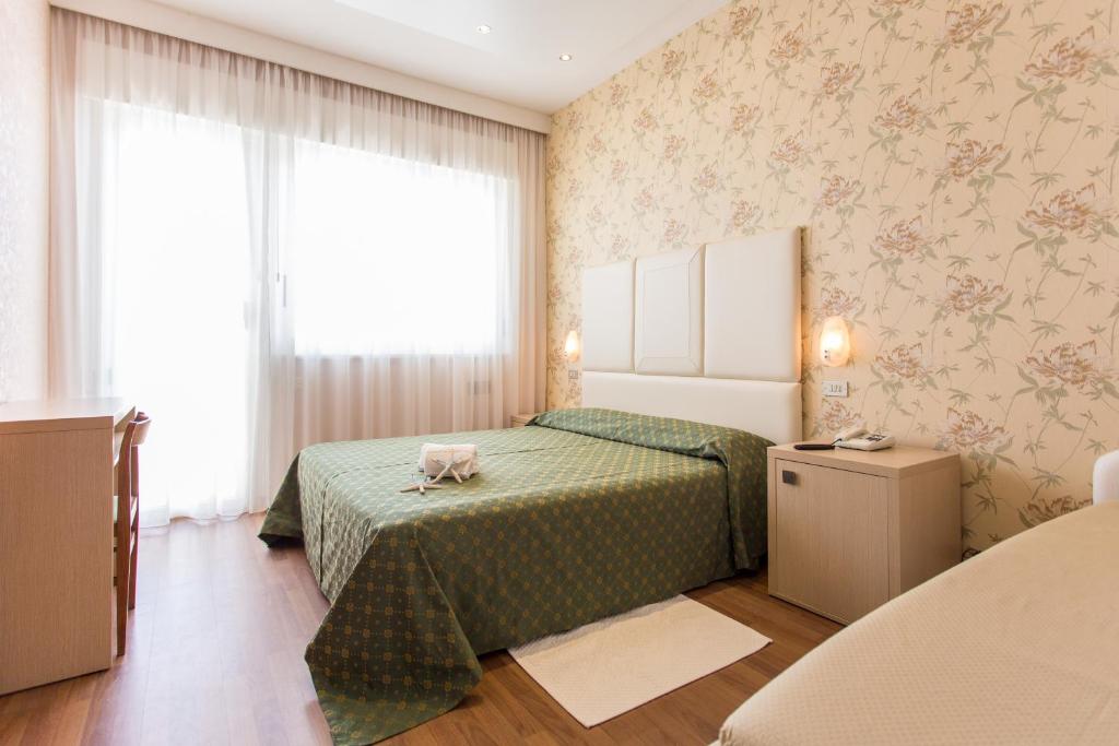 Postel nebo postele na pokoji v ubytování Hotel Benini