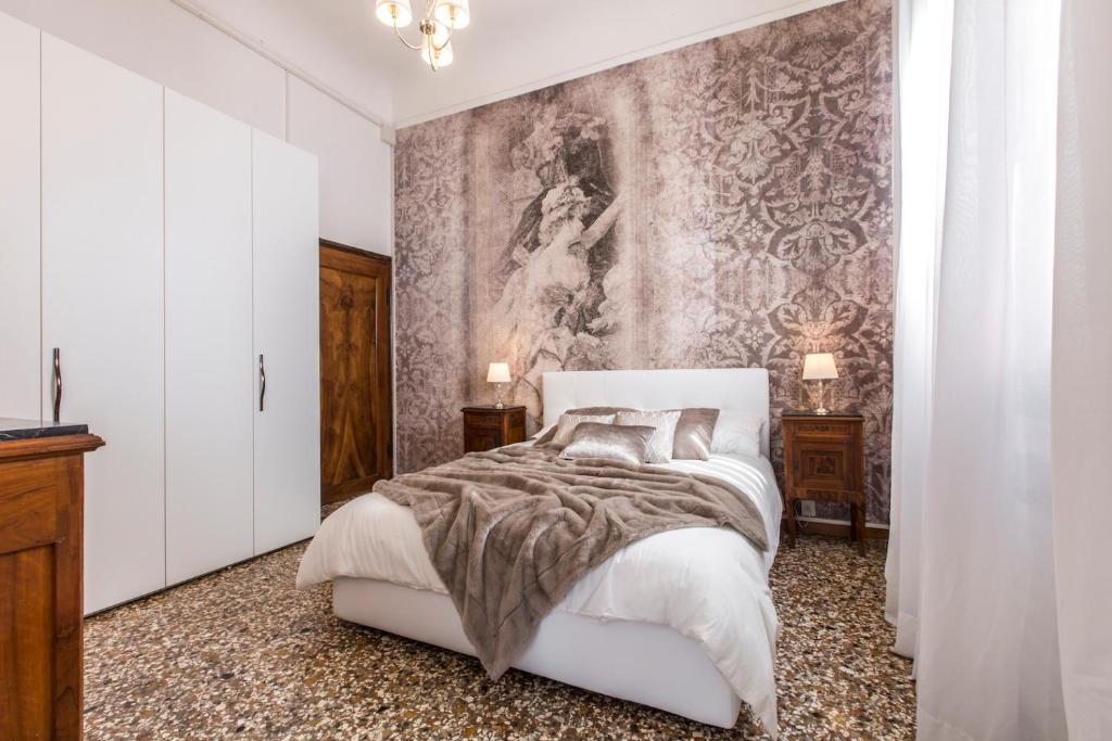 ヴェネツィアにあるRialto Design Boutique Apartment R&Rの白いベッド1台付きのベッドルーム1室(壁に絵画付)