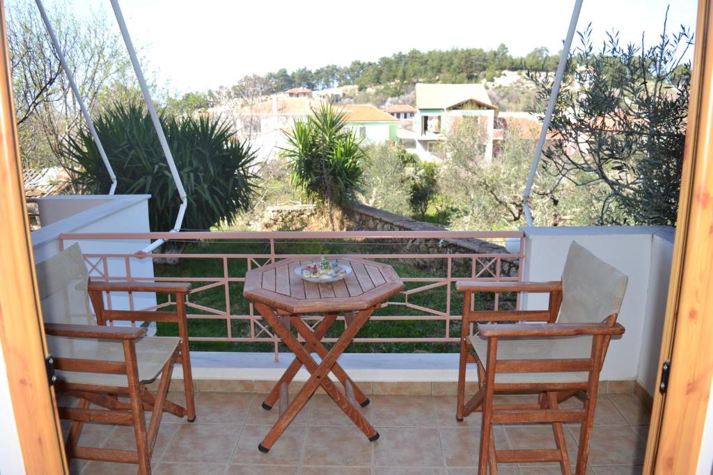a table and chairs on a balcony with a view at Liofos Studios in Kalamitsi