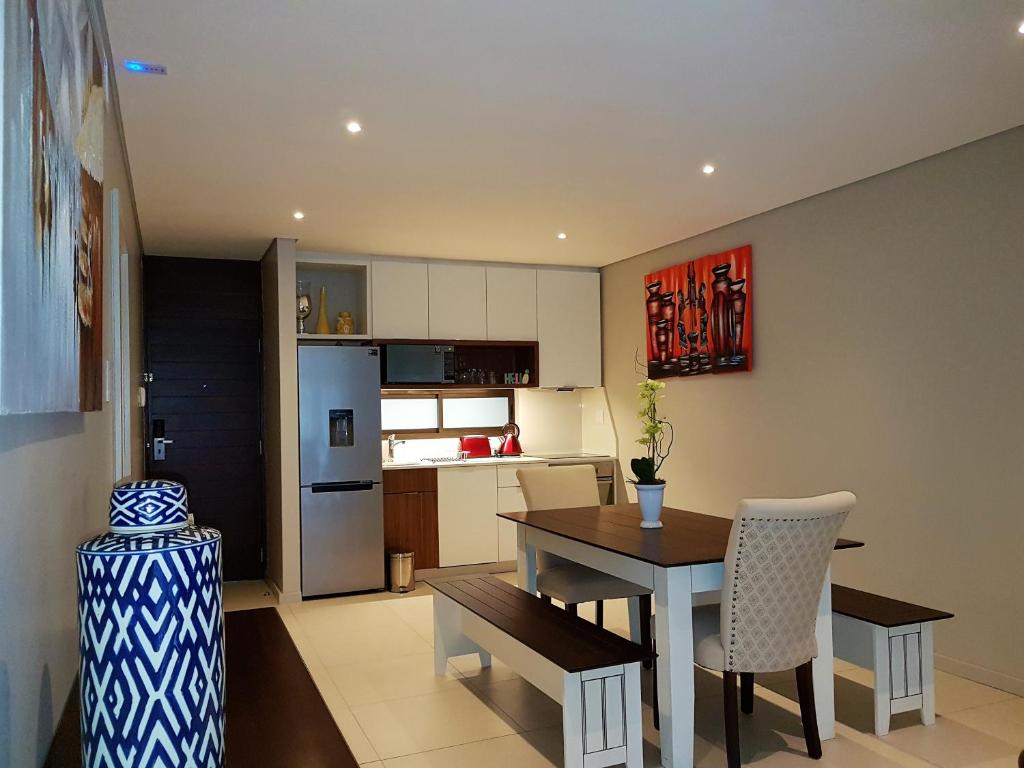 a kitchen and dining room with a table and chairs at Zimbali Suites 109 in Ballito