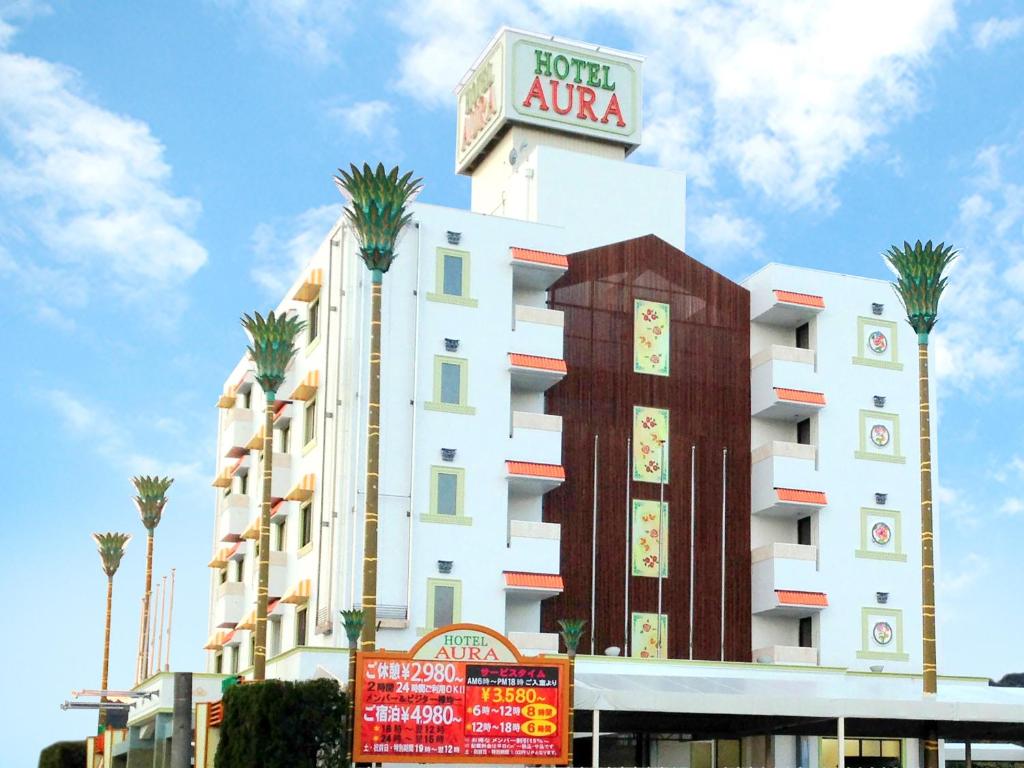 a building with a hotel aza sign and palm trees at AURA Seki Inter (Adult Only) in Kameyama